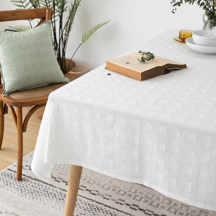 Tablecloth made of cotton blend with embossed square and circle relief