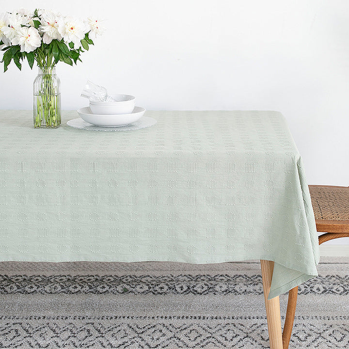 Tablecloth made of cotton blend with embossed square and circle relief