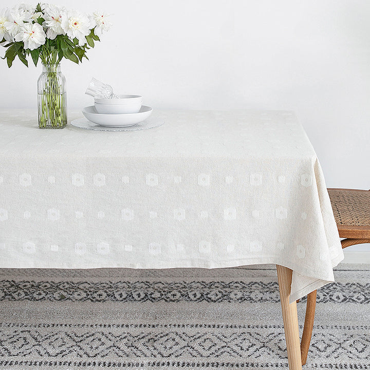 Tablecloth made of cotton blend with embossed square and circle relief