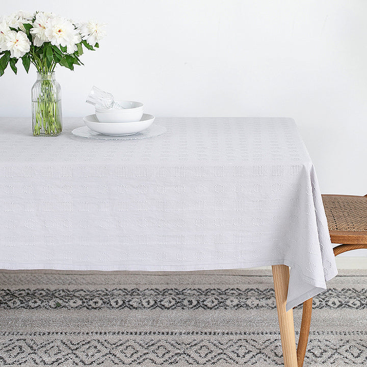 Tablecloth made of cotton blend with embossed square and circle relief
