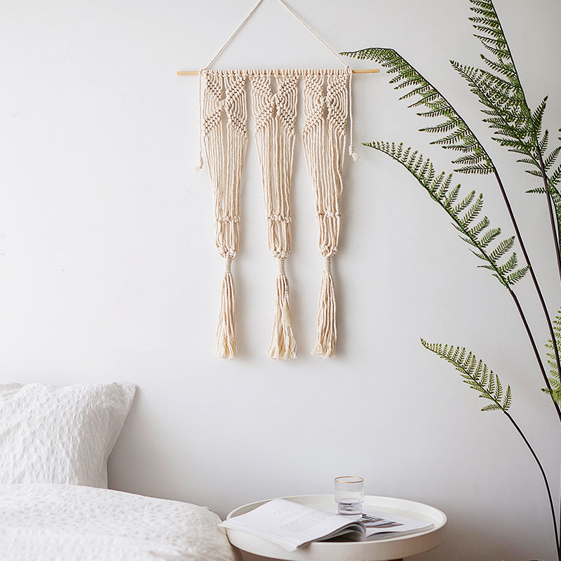 Macramé wall hanging with geometric triple tassel design and wooden rod