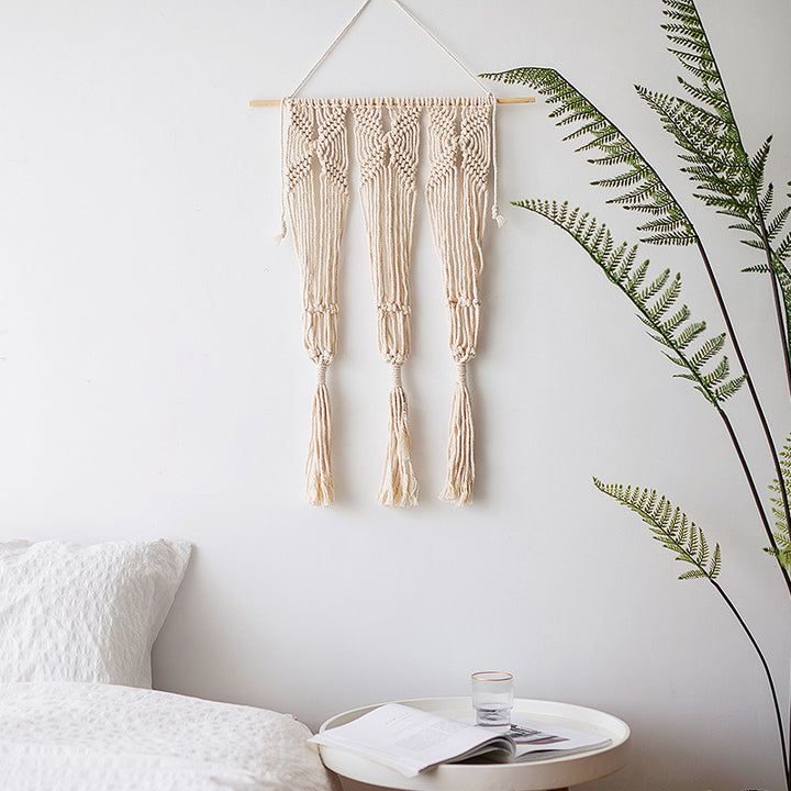 Macramé wall hanging with geometric triple tassel design and wooden rod