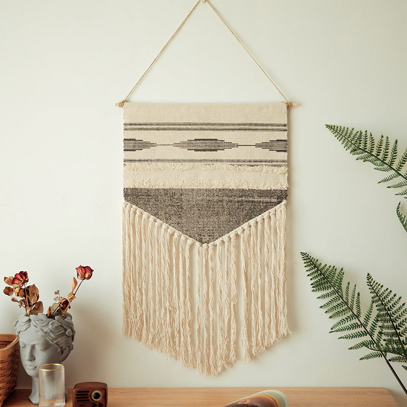 Handwoven wall hanging made of cotton blend with layered textures, wood rod and long fringes