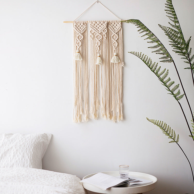 Macramé wall hanging with geometric triple tassel design and wooden rod
