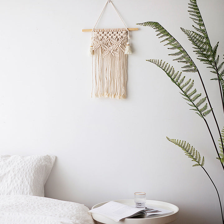 Macramé wall hanging with geometric triple tassel design and wooden rod