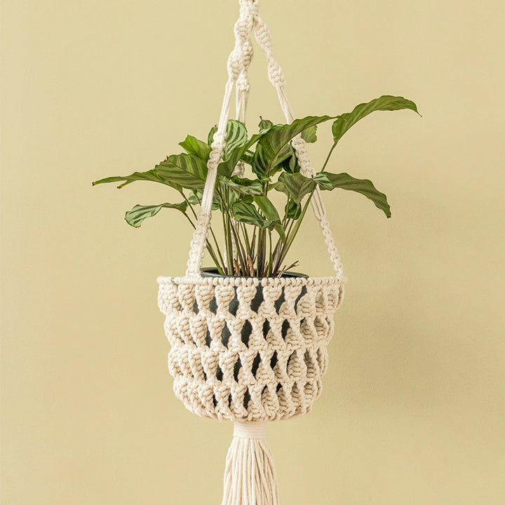 Macrame plant hanger made of cotton rope with tassels and adjustable suspension