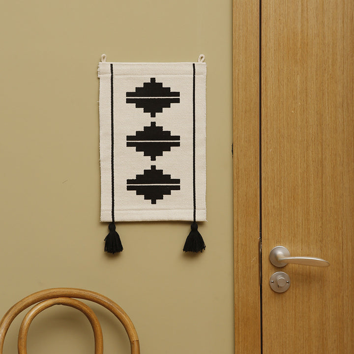 Woven wall hanging in minimalist geo pattern with decorative tassels and hanging loops