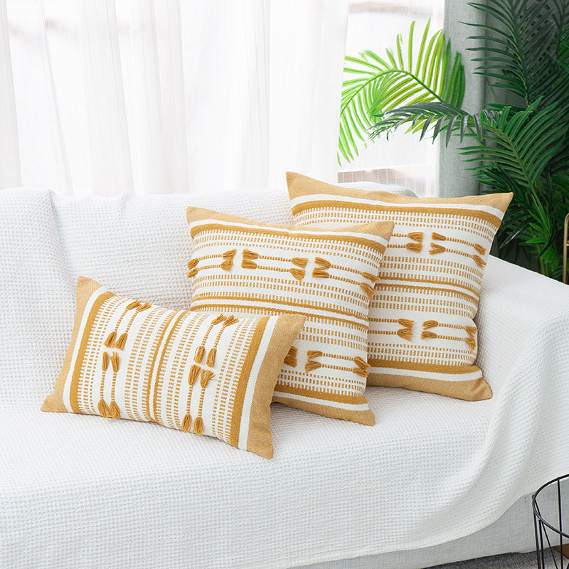 Woven decorative cushion cover with ordered tassel application and structured jacquard weaving