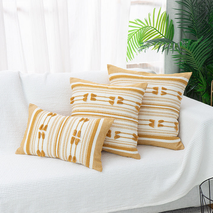 Woven decorative cushion cover with ordered tassel application and structured jacquard weaving