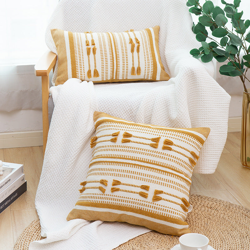 Woven decorative cushion cover with ordered tassel application and structured jacquard weaving