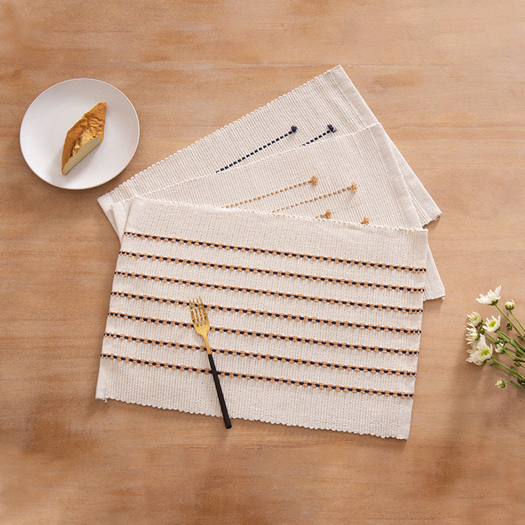 Woven placemats and table runners made of cotton blend with fine dot stripes and knot applications