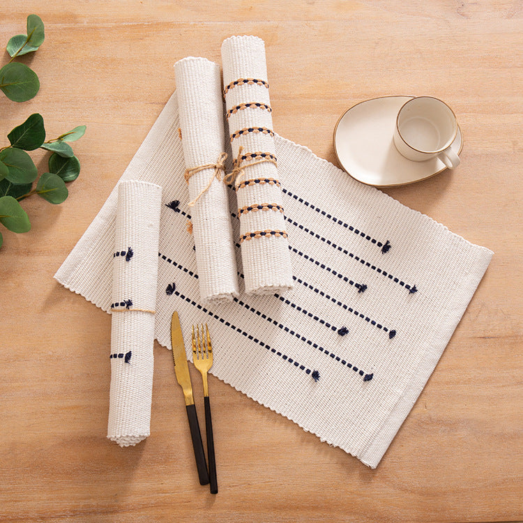 Woven placemats and table runners made of cotton blend with fine dot stripes and knot applications
