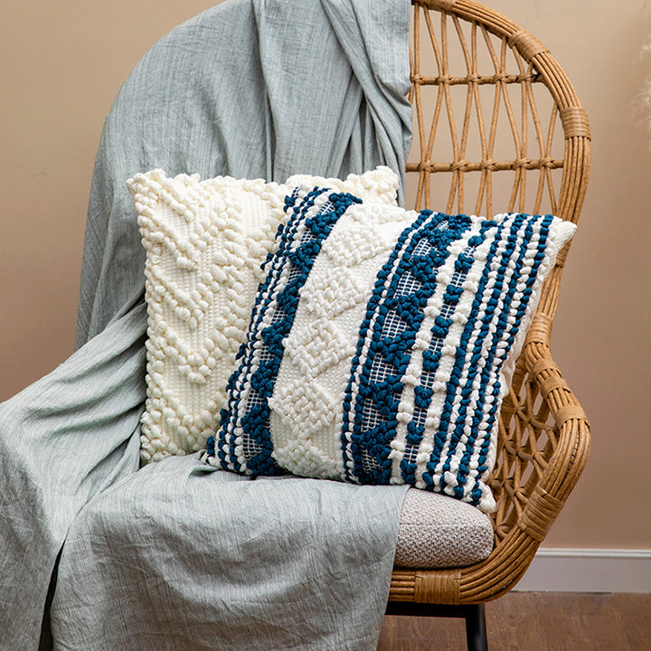 Square woven decorative cushion cover with crocheted appliqués and textured relief