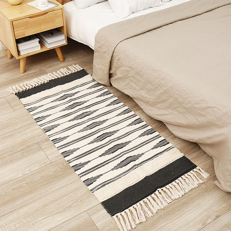 Flat-woven cotton runner with graphic stripe pattern and fringes