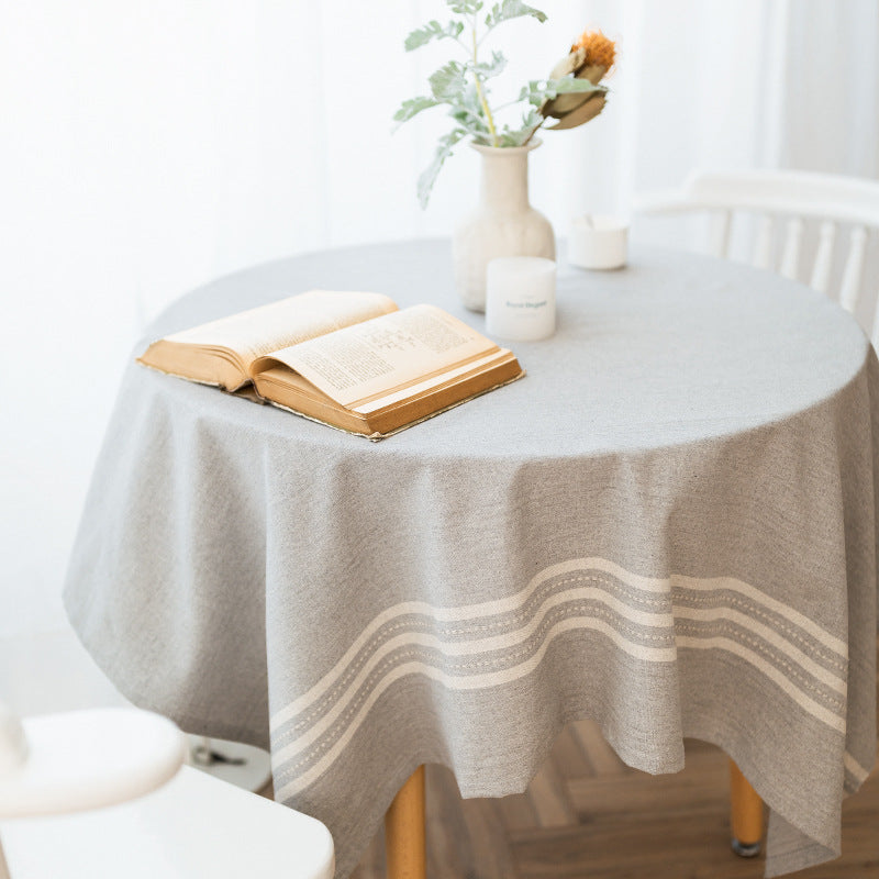 Rectangular tablecloth made of cotton-linen blend with subtle striped border and decorative tassels