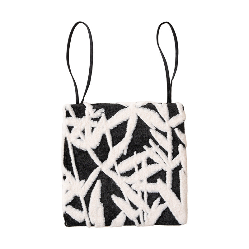 Padded seat cushion with hand-tufted leaf pattern and fastening ties