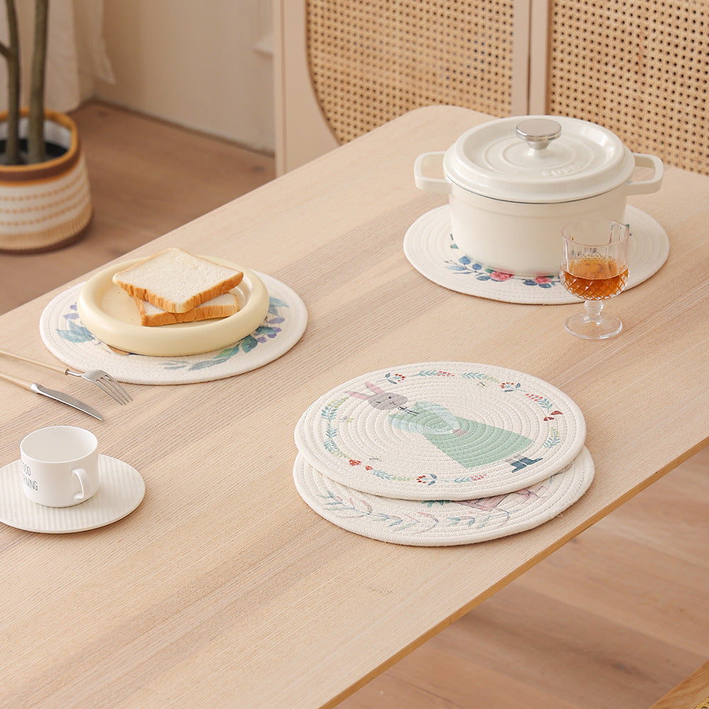 Round placemat made of woven cotton with a cute rhinoceros illustration and floral wreath