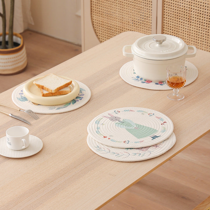 Round placemat made of woven cotton with a cute rhinoceros illustration and floral wreath