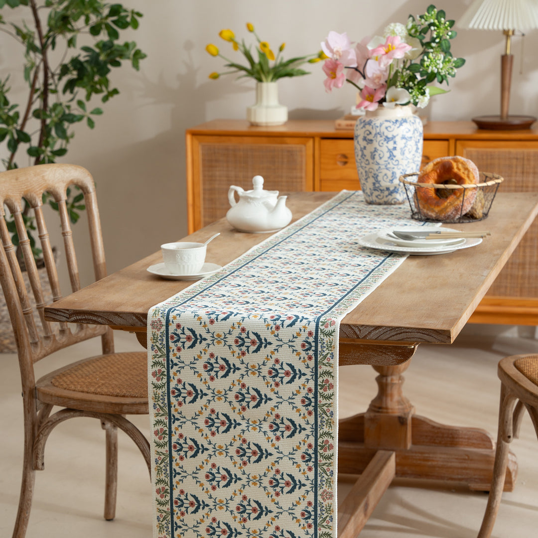 Vintage-inspired woven table runner with floral border and fringes