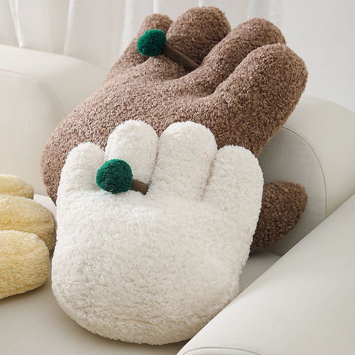 Plush decorative pillow in hand shape with pompon application