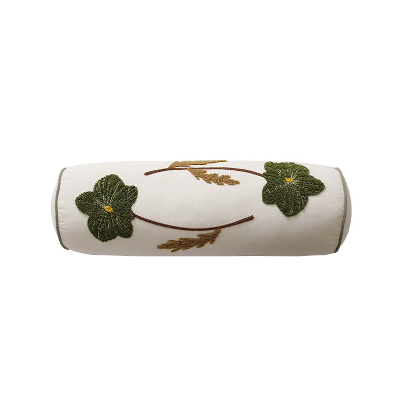 Bolster pillow with hand-stitched floral motif and decorative piping