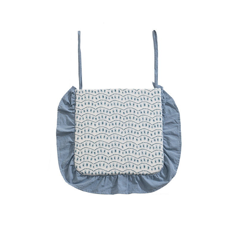 Padded chair cushion with ties, ruffled edge and embroidered hole pattern look