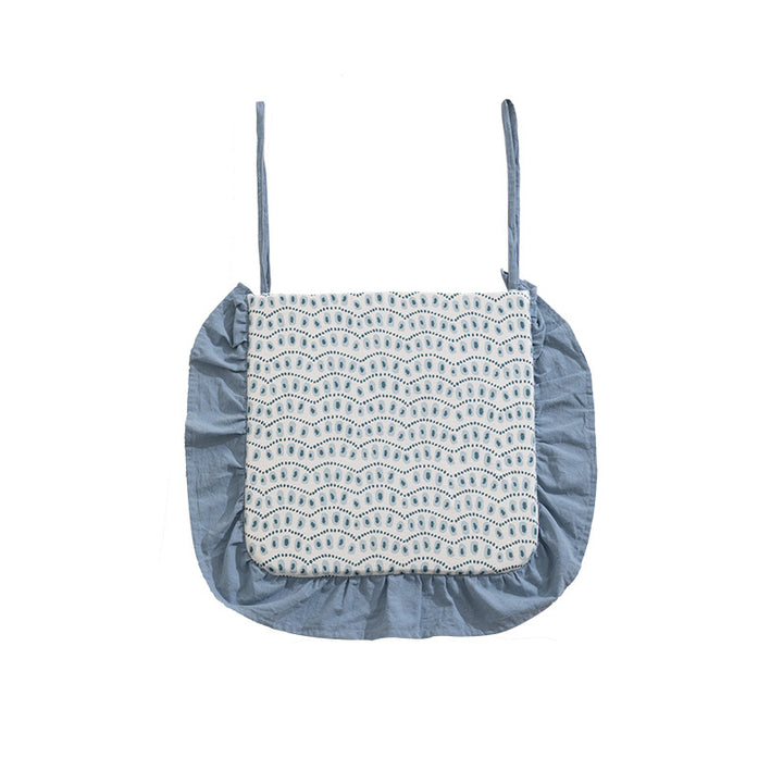 Padded chair cushion with ties, ruffled edge and embroidered hole pattern look
