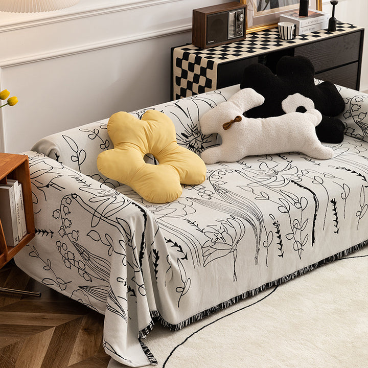 Light woven sofa cover with botanical line print and fringe hem