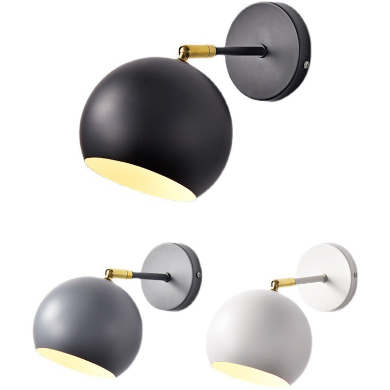 Adjustable matte metal globe wall lamp with brass pivot arm