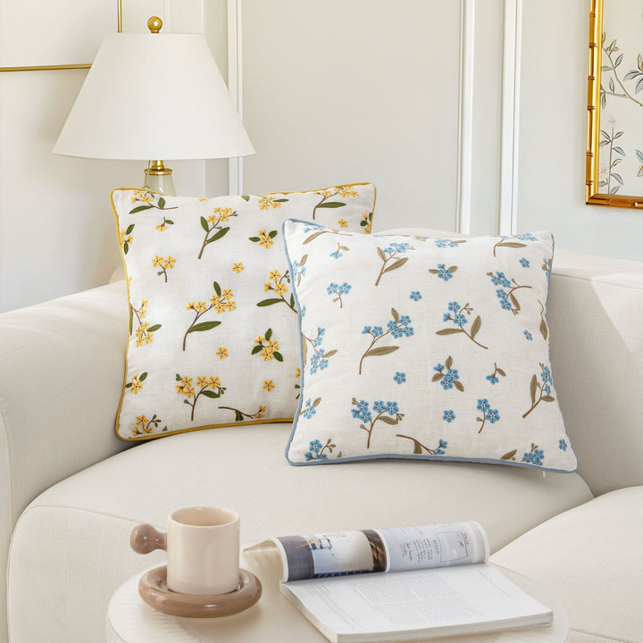 Embroidered linen decorative pillow with floral embroidery and piping