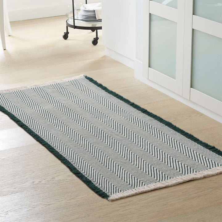 Handwoven cotton bath mat with herringbone pattern and fringes