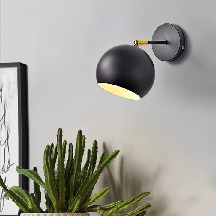 Adjustable matte metal globe wall lamp with brass pivot arm