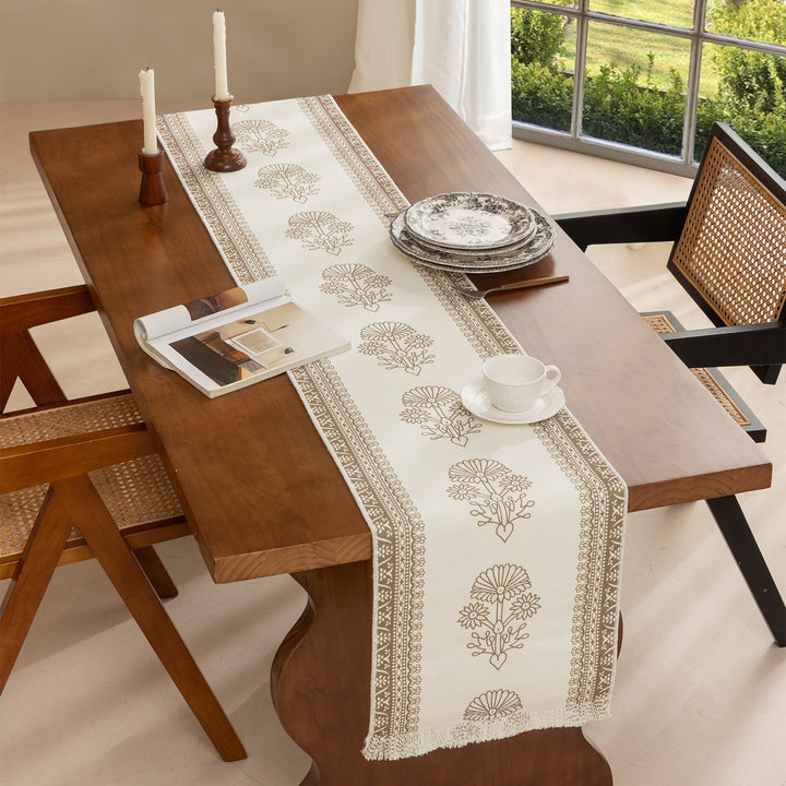 Woven decorative table runner with floral medallion borders and fringes