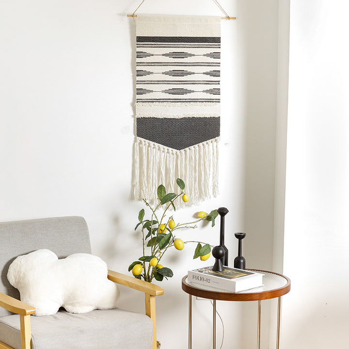 Handwoven wall hanging made of cotton blend with layered textures, wood rod and long fringes