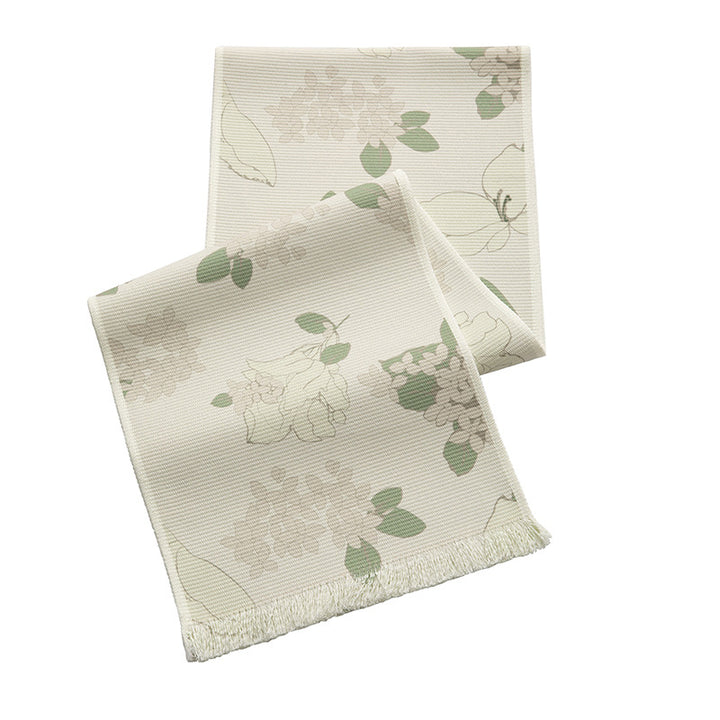 Woven table runner with floral jacquard pattern and fringed edge