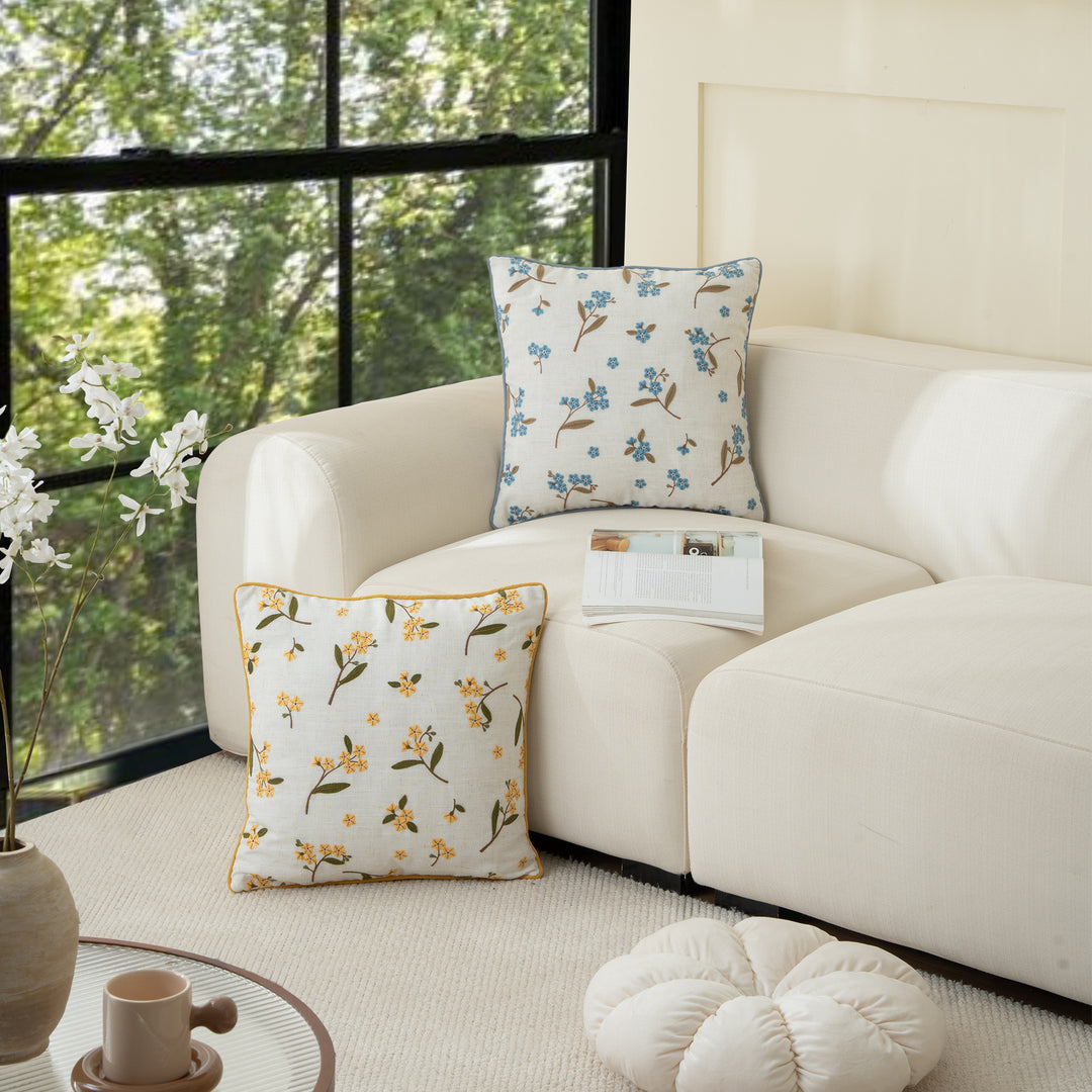 Decorative embroidered cushion cover made of linen blend with floral yellow flower appliqué and piping
