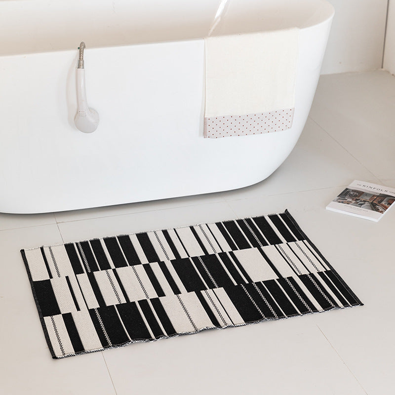 Flat-woven bath mat with abstract geometric pattern
