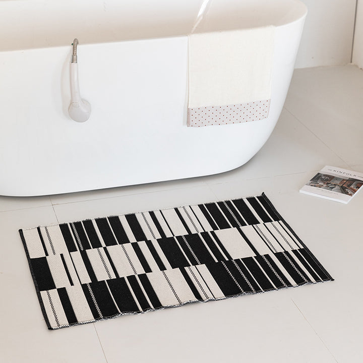 Flat-woven bath mat with abstract geometric pattern