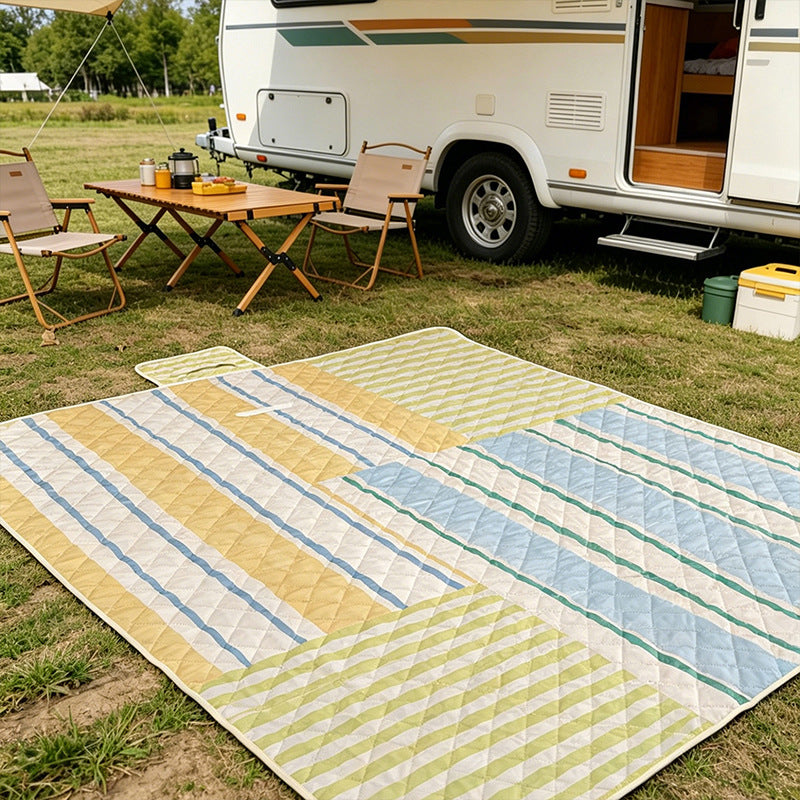 Padded outdoor picnic blanket with quilting, carrying flap and lightweight water-repellent cover