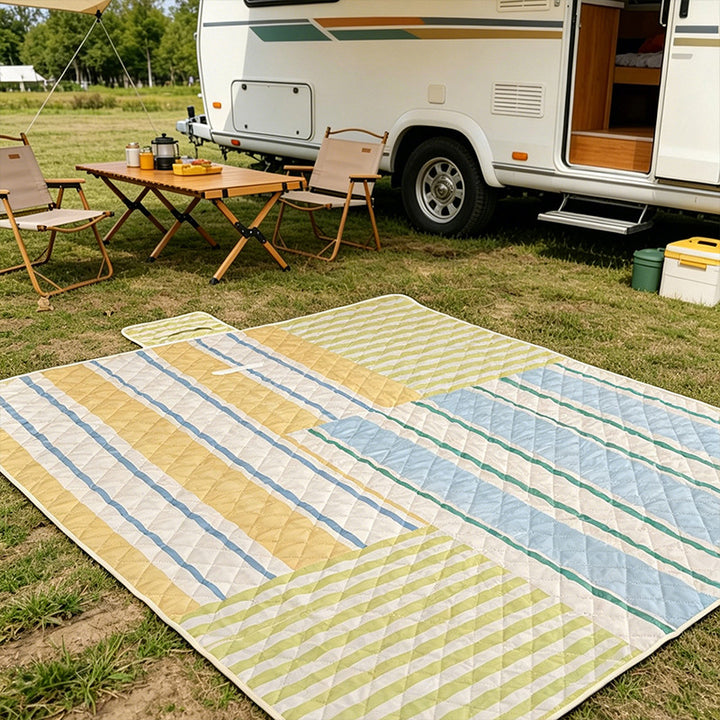 Padded outdoor picnic blanket with quilting, carrying flap and lightweight water-repellent cover