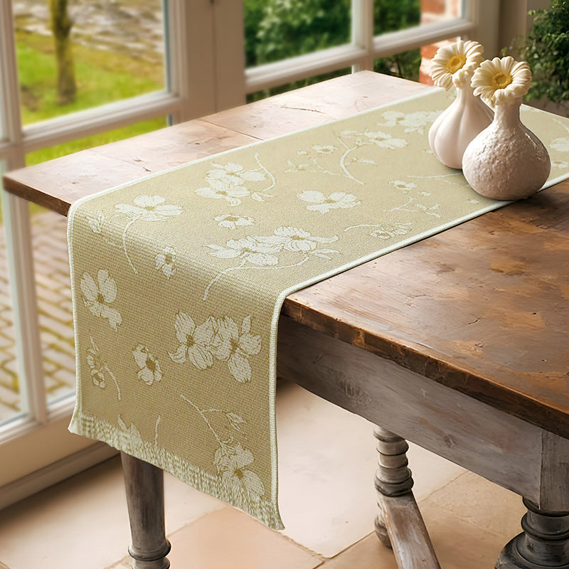 Woven table runner with floral jacquard pattern and fringed edge