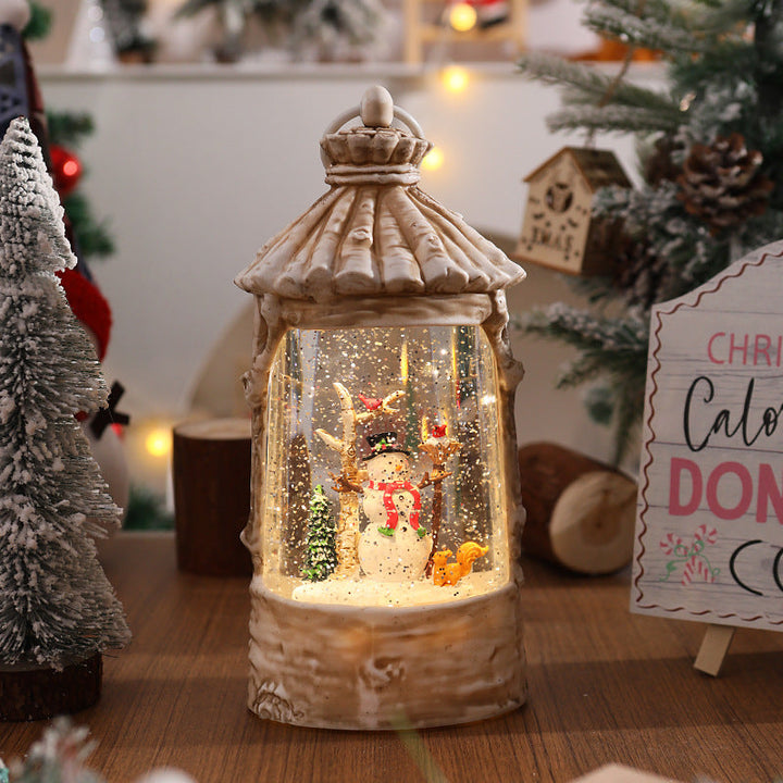Illuminated Christmas lantern with snow scenes
