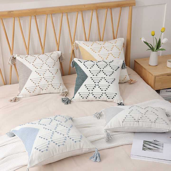 Decorative woven cushion cover with geometric tuft-relief and tassels
