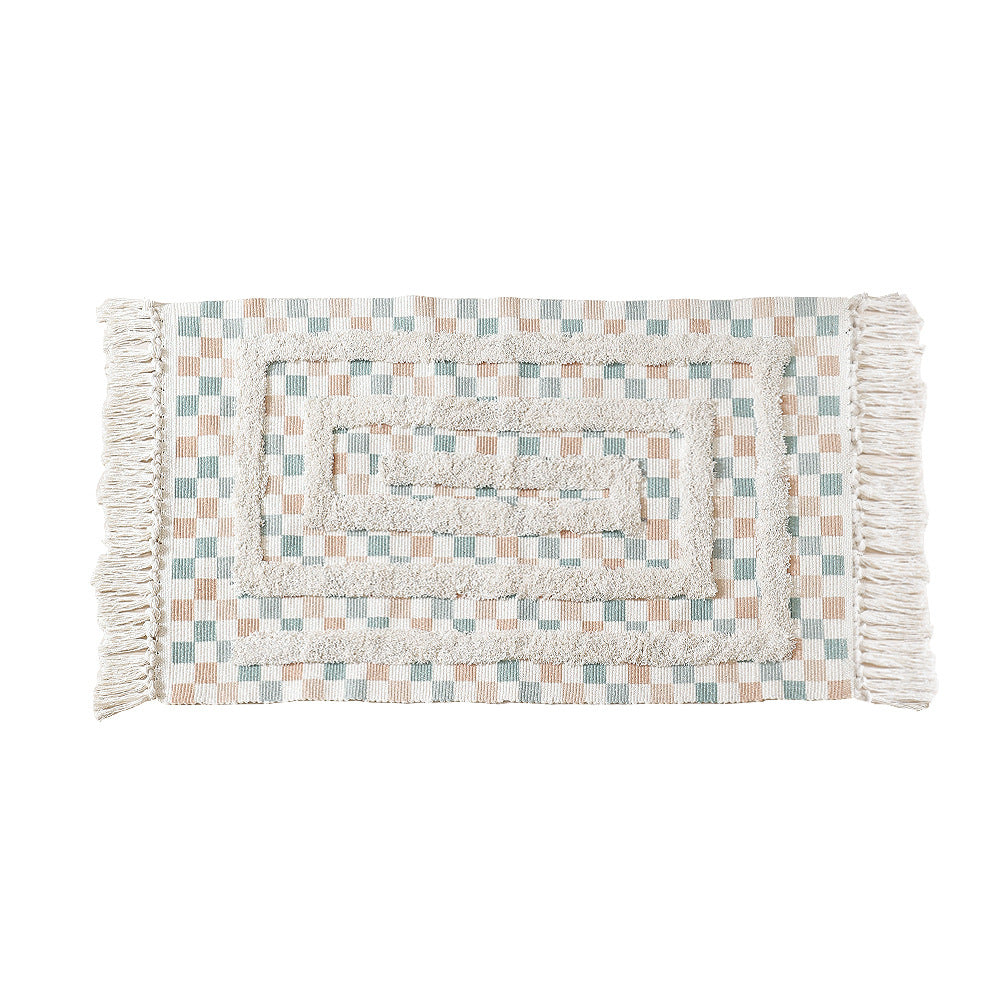 Hand-tufted bathroom mat with fringes, decorative dot-and-dash pattern and non-slip backing