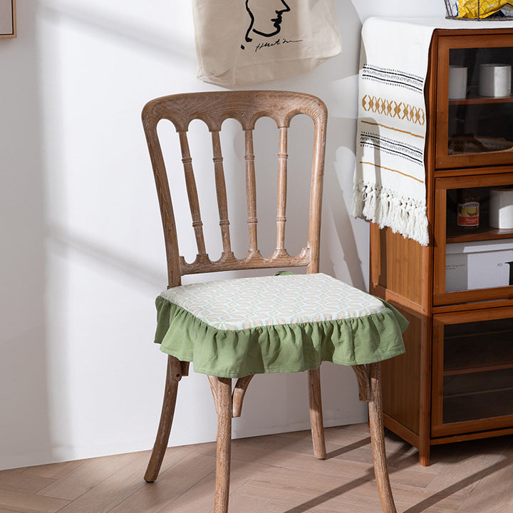 Padded chair cushion with ties, ruffled edge and embroidered hole pattern look