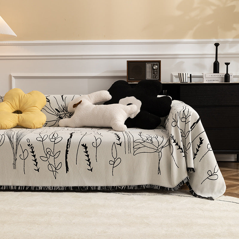 Fine woven sofa cover and furniture throw with floral line drawing and decorative fringed edge