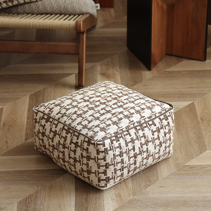 Square floor pouf with houndstooth jacquard, piping seam, and shape-stable foam core