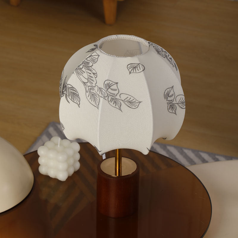 Sculptural table lamp with wooden base, brass stem, and cardboard shade