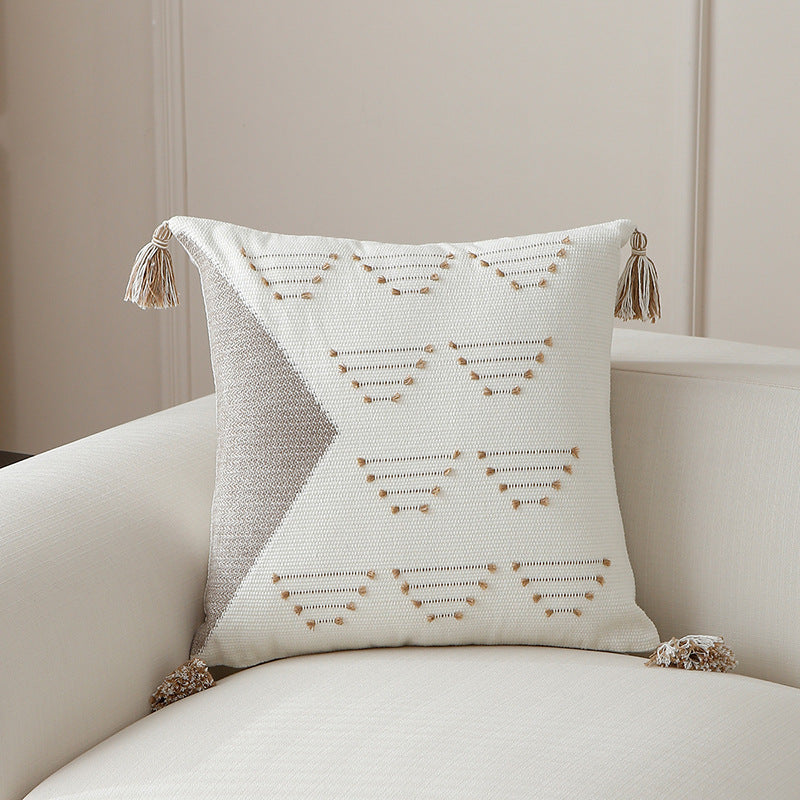 Decorative woven cushion cover with geometric tuft-relief and tassels