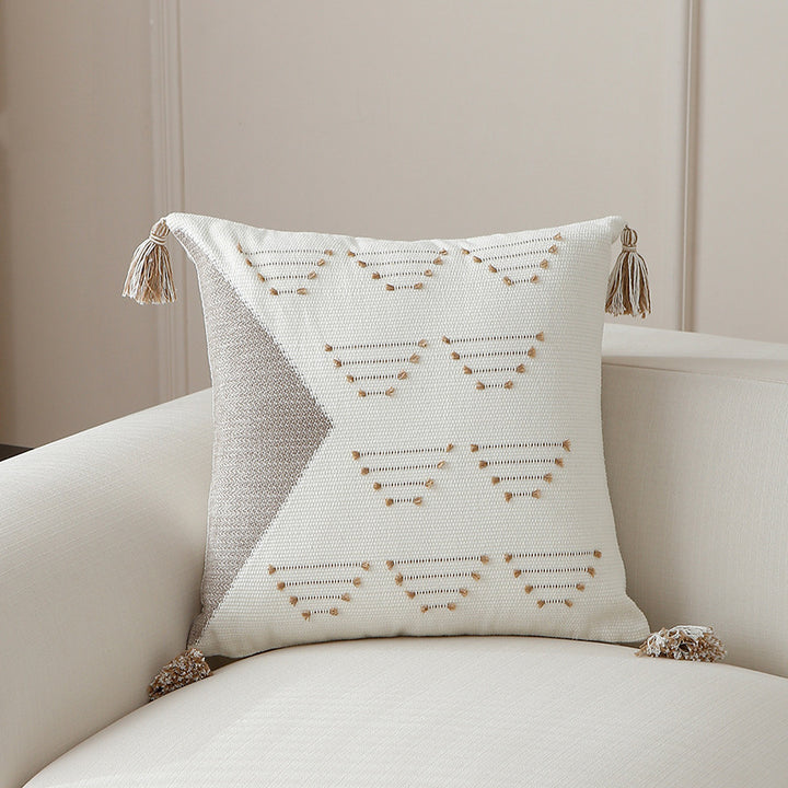 Decorative woven cushion cover with geometric tuft-relief and tassels